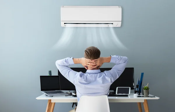 Uomo al computer in un ambiente fresco e deumidificato grazie all'impianto di condizionamento attivo