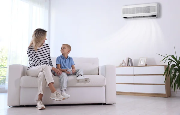 Mamma e bambino che giocano in casa con aria condizionata accesa, in un clima sicuro e piacevole