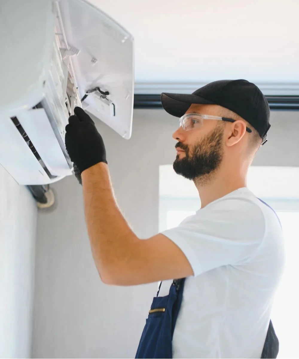 pronto-intervento-climatizzatori-termo365 Tecnico con attrezzatura professionale posizionato davanti all'unità esterna del condizionatore per l'inizio dell'intervento